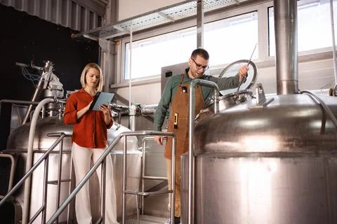 Brewery workers performing quality control and using digital tablet Stock Photos