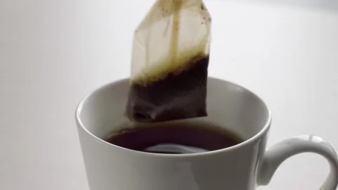Brewing a bag of black tea in a ceramic mug. White background Stock Footage 168368495