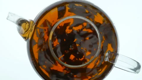 Brewing black tea in a glass teapot. Top view on white background Stock Footage 96992063