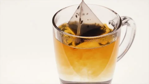 Brewing black tea with tea bag over white background Stock Footage 96434397