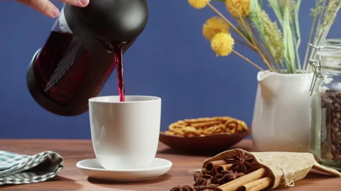 Brewing black tea in a teapot close-up. Drinking hot herbal drink on blue Stock Footage 168558794