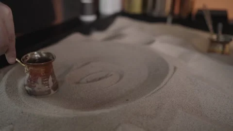 Brewing coffee in a cezve on the sand Stock Footage 267971999