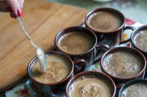 Brewing coffee in a cup on the table by the window Stock Photos