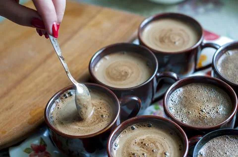Brewing coffee in a cup on the table by the window Stock Photos