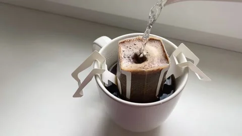 Brewing coffee at home on a white background. Drip coffee in a white cup Stock Footage 217437143
