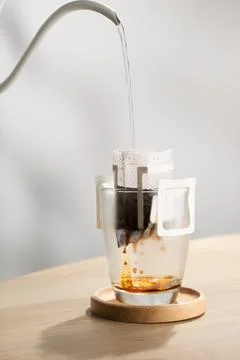 Brewing coffee through pre-made paper filters. Stock Photos