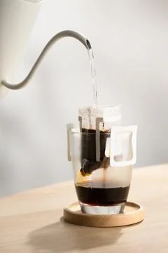Brewing coffee through pre-made paper filters. Stock Photos