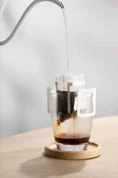 Brewing coffee through pre-made paper filters. Stock Photos