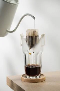 Brewing coffee through pre-made paper filters. Stock Photos
