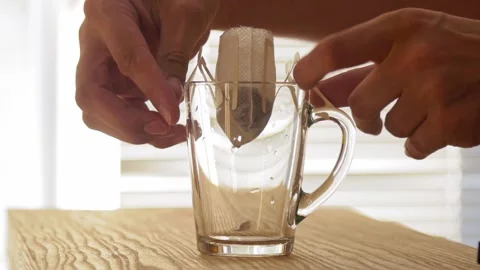Brewing drip coffee bag (filter coffee) into transparent glass mug Stockbeeldmateriaal 156976769