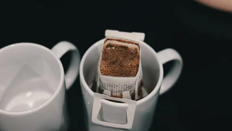 Brewing drip coffee on a kitchen. A white mug holds a filter dripping Stock Footage 308938943