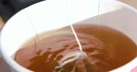 Brewing green tea with mango (in a bag) in a disposable cup, dipping and lif Stock Footage 345919158