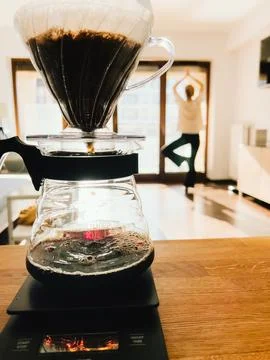 Brewing specialty coffee using precision scale, wooden surface highlighting Stock-Fotos