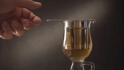 Brewing tea in a glass Cup using a metal strainer. Close-up of a man's hand Stock Footage 107884261