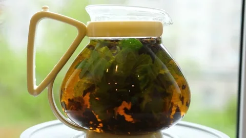 Brewing tea with leaves of currant, lemon balm, mint, raspberry in a glass Video stock 131023399