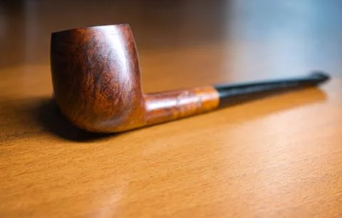 Briar smoking pipe on the table, focus on the bowl Stock Photos