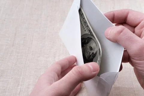 Bribe one hundred dollars in a white envelope. Stock Photos