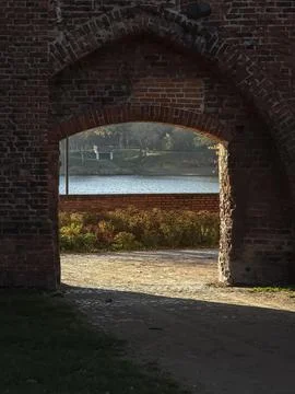 Brick archway framing a riverside view Stock Photos