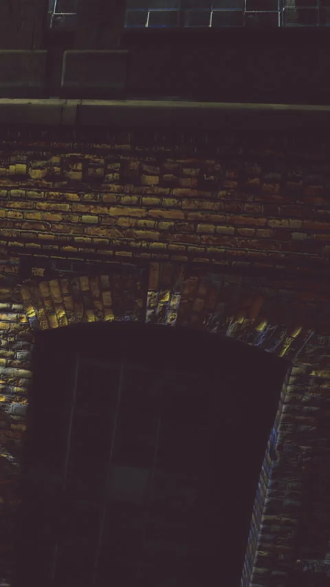 Brick archway glows warmly under soft evening light in quiet urban setting Stock Footage 335233636