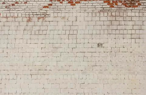 Brick background, the wall of an old brick building painted white with elemen Stock Photos