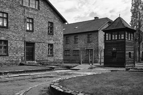 Brick barracks and guard tower in Auschwitz concentration camp Stock Photos