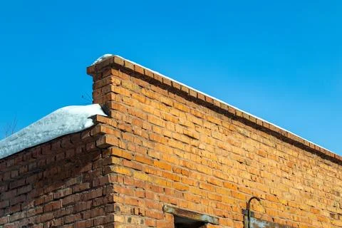 Brick brown old wall covered with snow Stock Photos