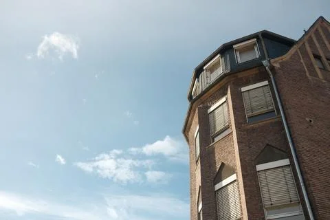 A brick building with a blue sky in the background Stock Photos