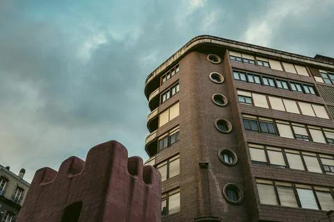 Brick building with circular windows under a cloudy sky................ Stock Photos
