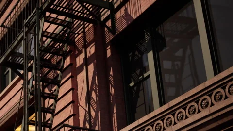 Brick building with fire escape at sunset in urban area Stock Footage 342063315