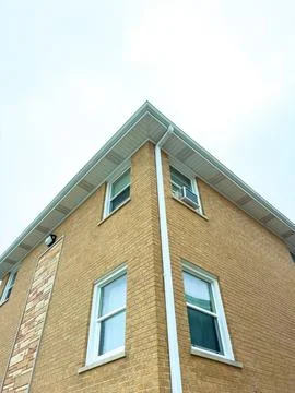 A brick building has a close-up view of its corner, showing windows and an ai Fotos de archivo