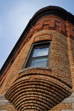 Brick building with a rounded window jutting out of a corner Foto stock