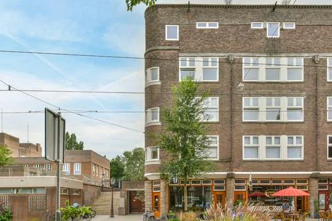 A brick building with a tree in front of it Stock Photos