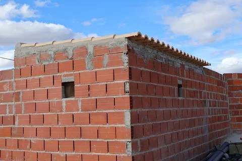Brick building under construction with a blue sky and white clouds in the b.. Stock Photos