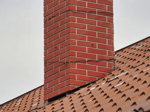 Brick chimney stack on the modern contemporary house rooftop Stock Photos