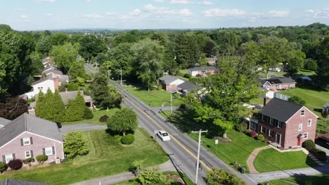 Brick colonial homes line quiet tree-shaded street in Pennsylvania suburb Stockbeeldmateriaal 340991584