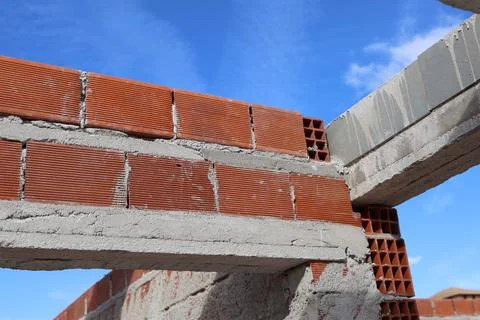 Brick construction with blue sky background, building a new structure Stock Photos