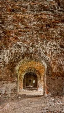 Brick corridor on the lower level in an old abandoned and decaying building Stock Photos