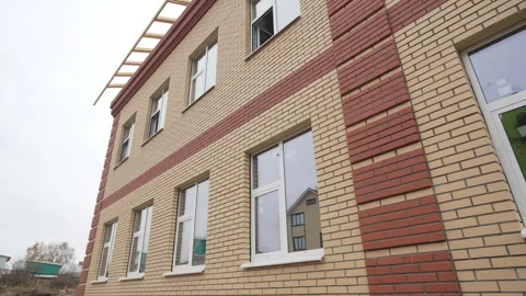 Brick facade gleams under daylight with new plastic windows Stock Footage 312404149