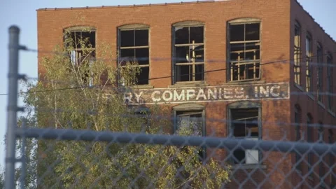 Brick factory building through barbed wire and chain link fence Stock Footage 304373437