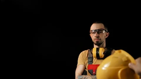 A brick falling from height towards a workers head which. Work safety concept Stock Footage 98980909