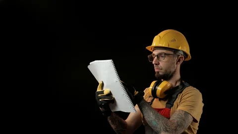 A brick falling from height towards a workers head which. Work safety concept Stock Footage 98980953