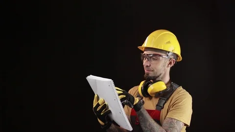 A brick falling from height towards a workers head which. Work safety concept Stock Footage 98981448