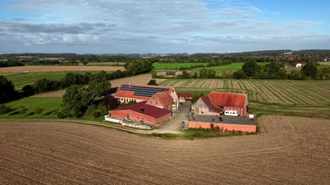 Brick farm property with solar panels on red tile roof, half-timbered barn Stock Footage 346796668