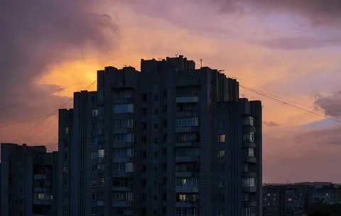 Brick high-rise in the rays of the setting sun and red fiery sky. 스톡 사진