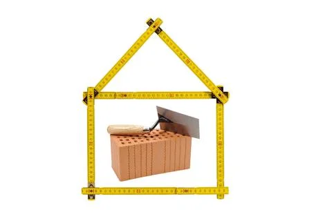 Brick for house construction and yard stick isolated over white background... Fotos de archivo