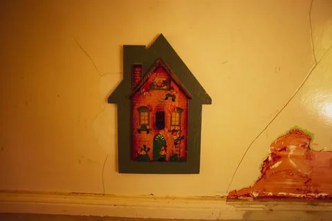 Brick house shaped kitchen light switch on white cracked wall Stock-Fotos