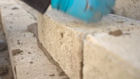 Brick Layer Lays Block On Mortar And Knocks It Into Place With Fist 스톡 동영상 239677759