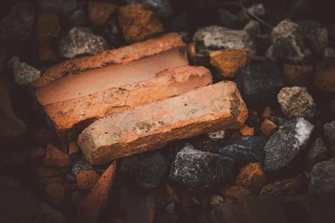 A brick is laying on the ground next to some rocks Foto stock