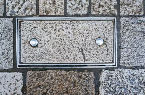 Brick in a metal frame with two rivets. Two metal pins are driven into the st Stock Photos