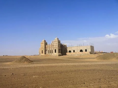 Brick Mosque Under Clear Blue Sky in Desert Landscape Foto stock